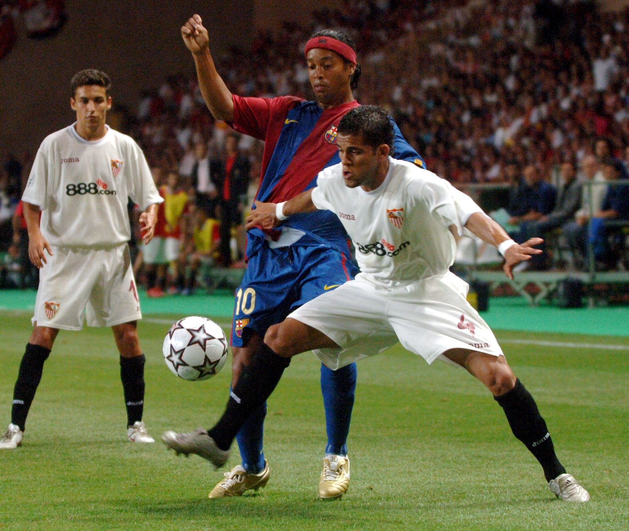 Ronaldinho fights for possession with Dani Alves while a young Jesus Navas watches on. EFE