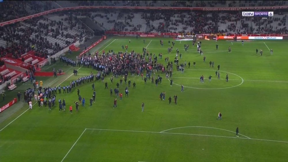 Lille fans invade the pitch. beINSports