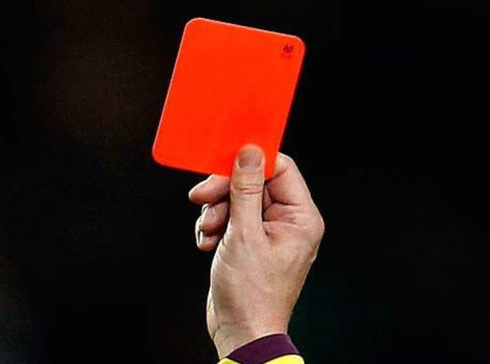 Un árbitro muestra una tarjeta roja durante un partido. Twitter