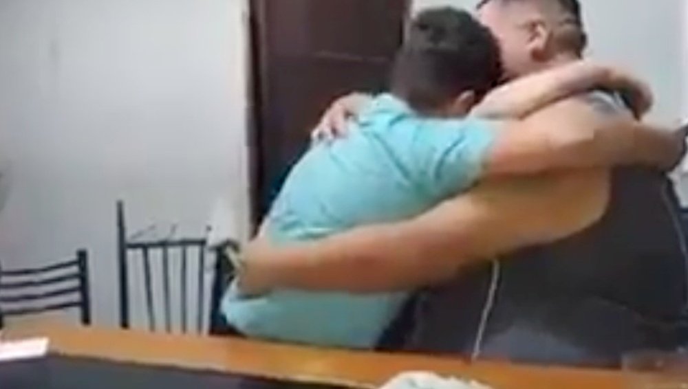 Un padre abraza a sus dos hijos tras regalarle entradas de Talleres. ESPN