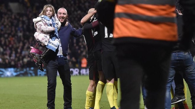 Un padre celebra con su hija en brazos uno de los tantos del Manchester City.