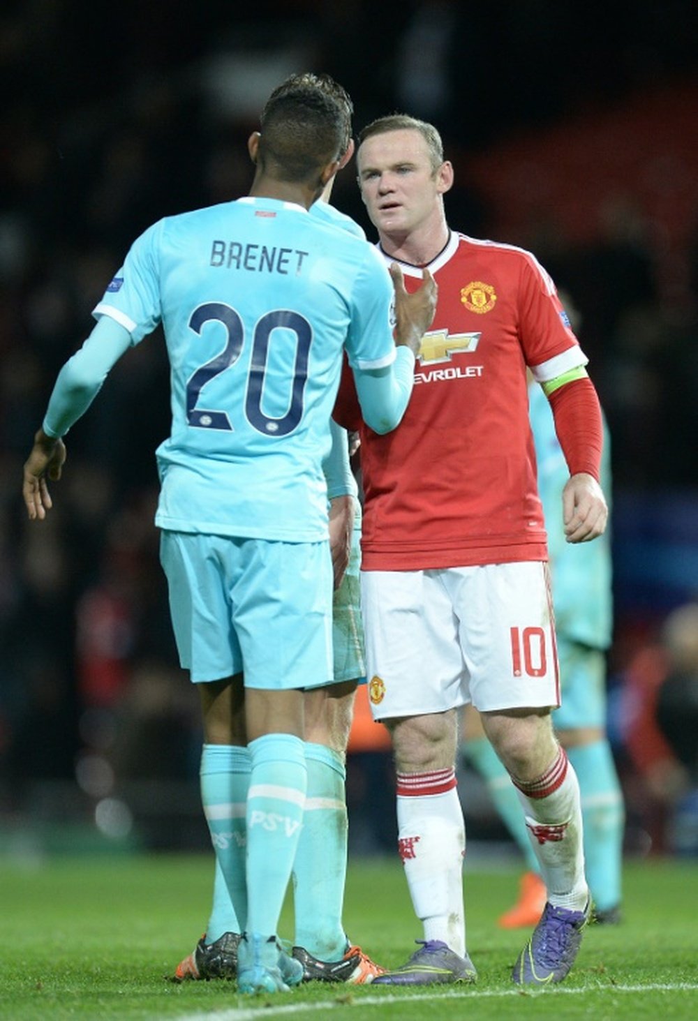 Wayne Rooney charla con Joshua Brenet al término del encuentro que enfrentó a Manchester United y PSV Eindhoven en Champions League. AFP