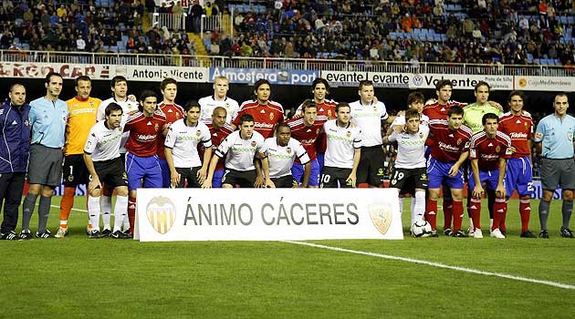 Jugadores de Valencia y Zaragoza posan con la pancarta de ánimo para Cáceres