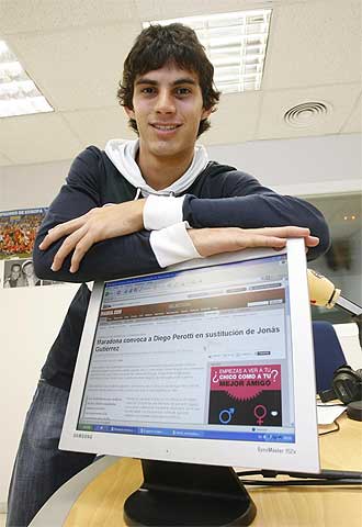 Diego perotti posa en la redaccion de marca sevilla delante de una pantalla con la noticia de su con