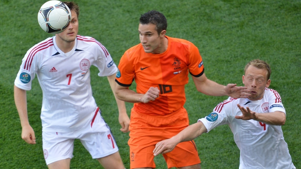 Van Persie lucha contra dos jugadores de Dinamarca por el balón