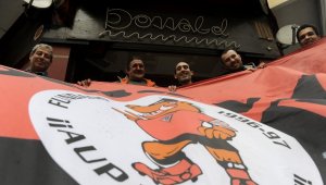 Miembros del Komando Kemando exhiben su pancarta en el bar Donald, su sede social