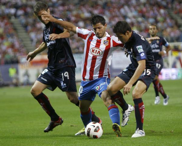 Atlético de Madrid Kun Agüero disputa el balón con Eguren Sporting de Gijón y Canella durante su partido de fútbol españoles de Primera División en el estadio Vicente Calderón en Madrid