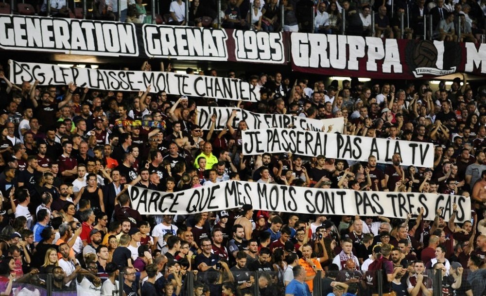 Metz supporters hold banners that got their match with PSG halted for three minutes. AFP