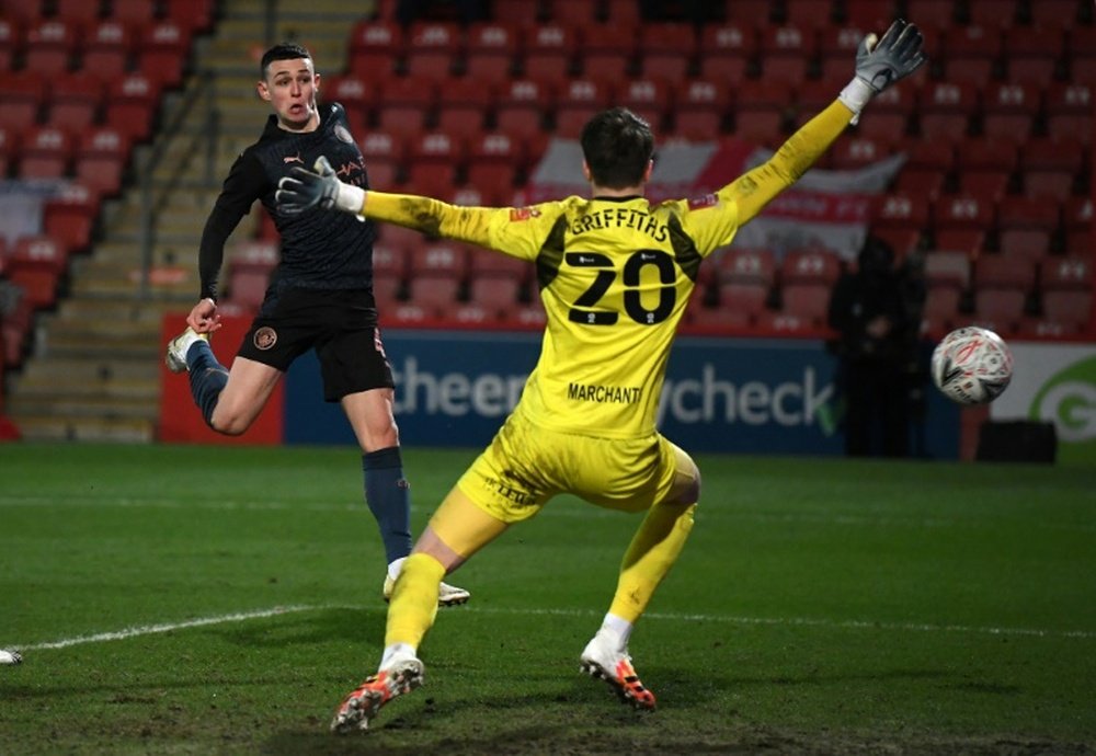 Manchester City midfielder Phil Foden (left) scores against Cheltenham. AFP