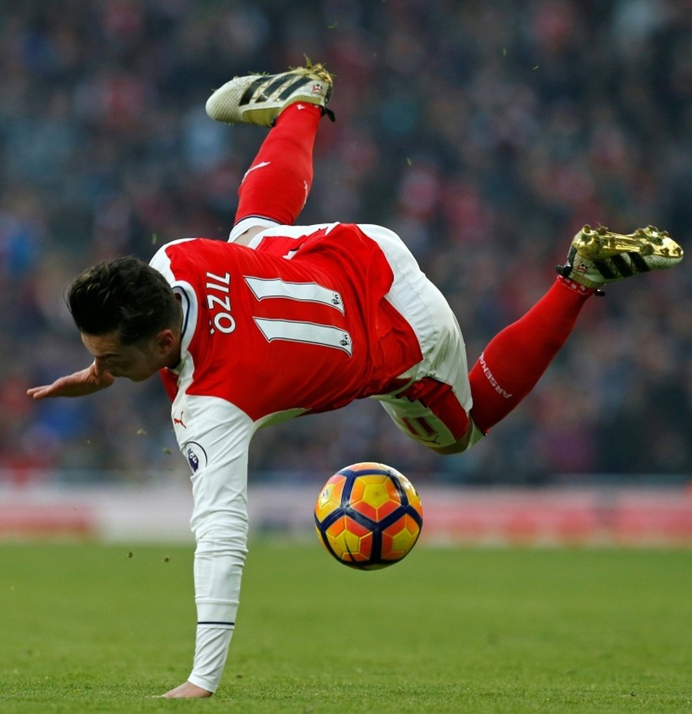 Arsenals Mesut Ozil takes a fall after being tackled during the match against Burnley in London