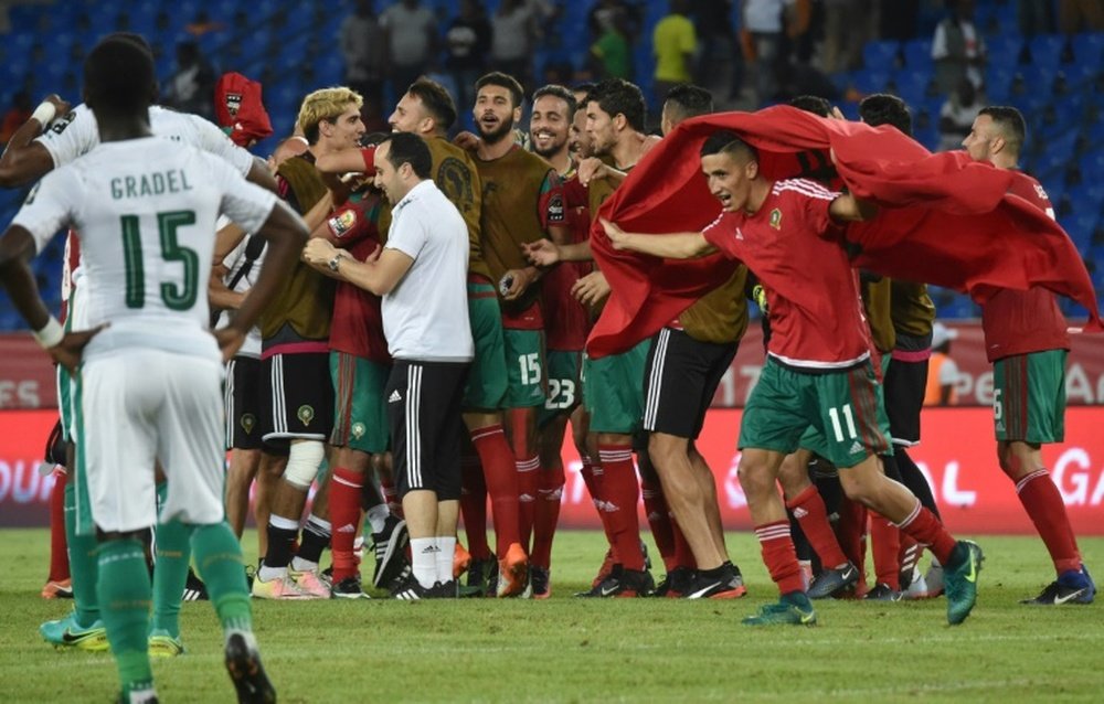 Ivory Coast players watch as Moroccan players celebrate at the end of their match. AFP