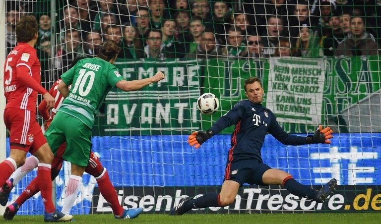 Bremens midfielder Max Kruse (2L) scores against Bayern Munichs goalkeeper Manuel Neuer