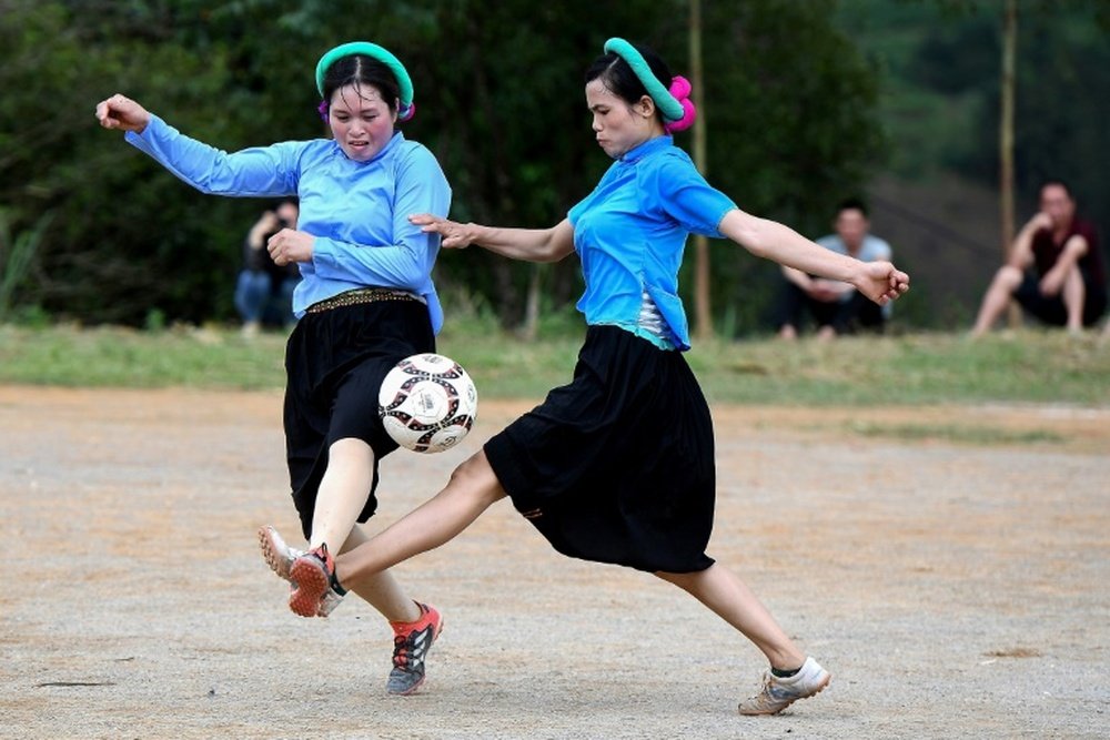 Ethnic San Chi women dressed in traditional costumes play a friendly football match. AFP