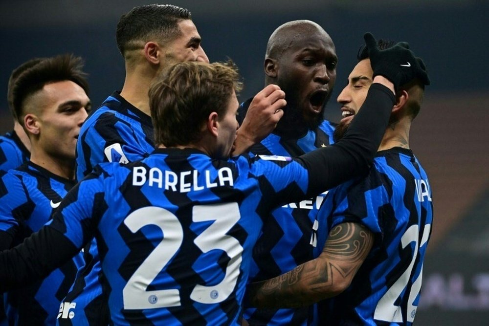 Inter Milan midfielder Arturo Vidal (R) and Nicolo Barella (C) celebrate after scoring.AFP