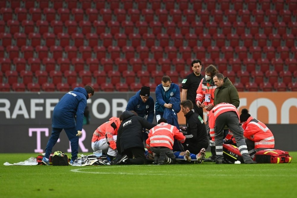 Schalke forward Mark Uth receives medical treatment. AFP