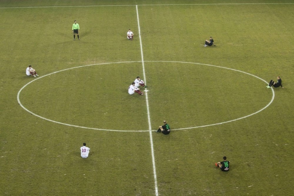 Greek football players of AEL Larissa F.C (L), who have been banned from wearing refugee crisis awareness messages on their shirts, and Acharnaikos F.C held a sit-in protest at the start of a match in favor of migrants and refugees January 29, 2016