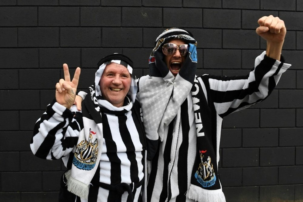 Newcastle fans pose in Arab-style clothing at St James Park. AFP