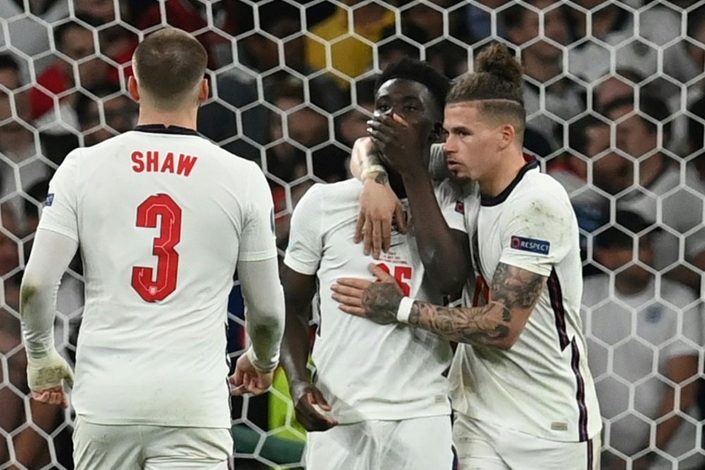 Saka (centre) was racially abused online after missing the decisive penalty in the shoot-out. AFP