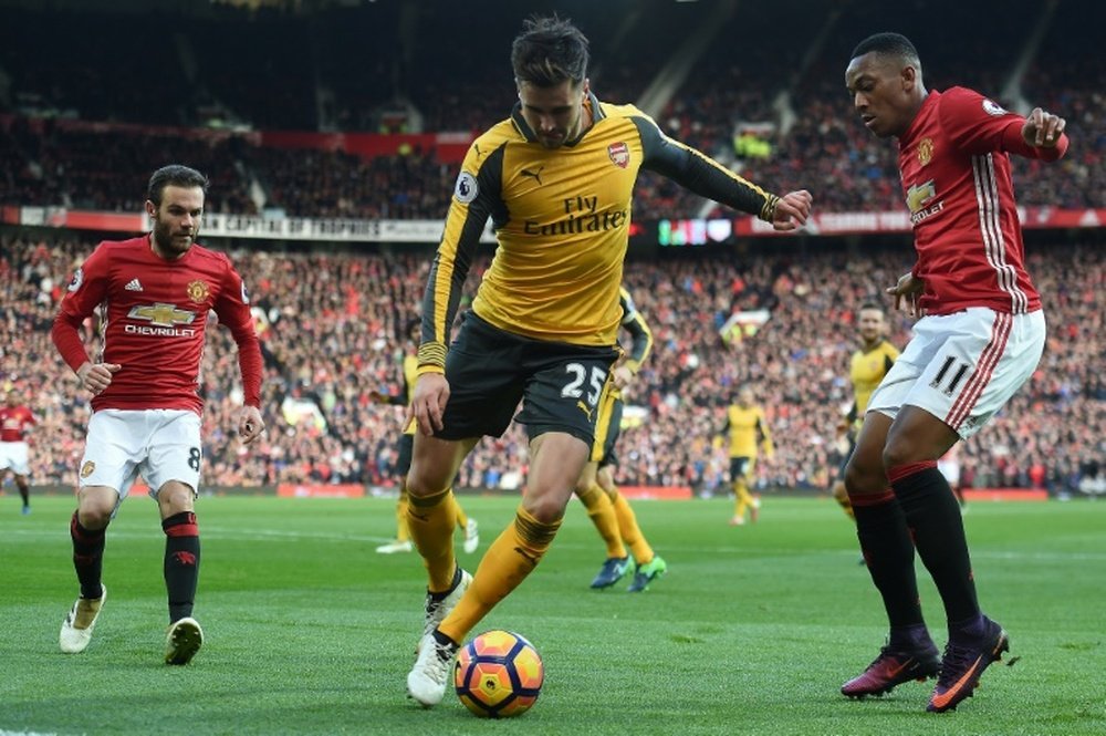 Arsenals defender Carl Jenkinson (C) vies with Manchester Uniteds striker Anthony Martial (R) and midfielder Juan Mata during the English Premier League football match November 19, 2016