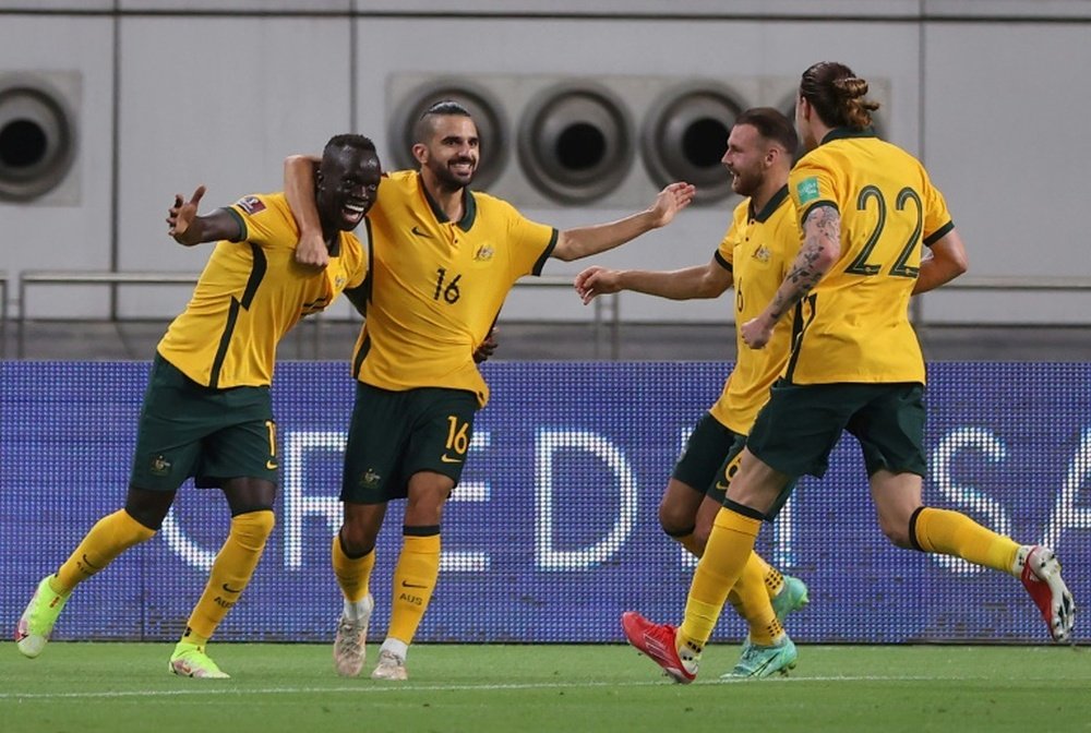 Awer Mabil celebrates with teammates after scoring the opener against China. AFP