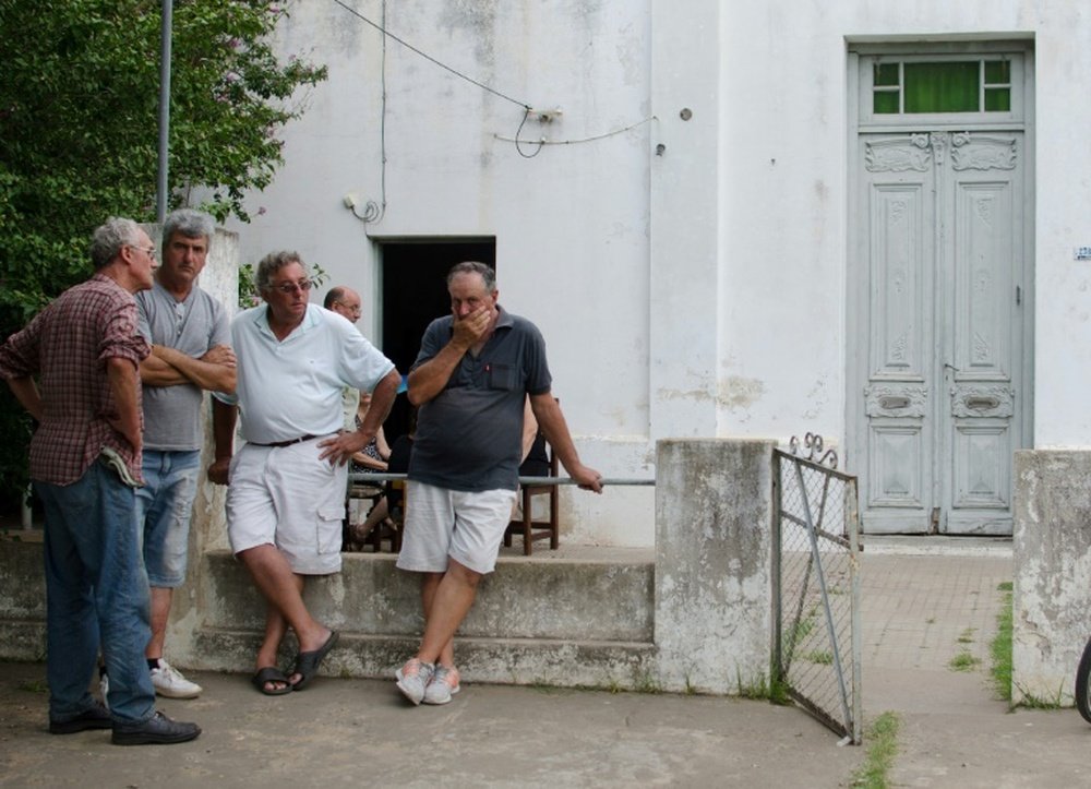 Friends console Emiliano Sala's father Horatio (second from right) outside his house. AFP