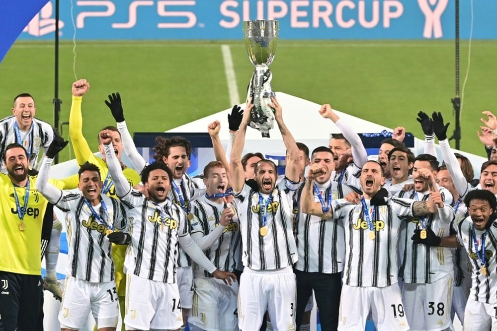 Giorgio Chiellini (C) lifts the trophy after Juventus beat Napoli to win the Italian Super Cup. AFP