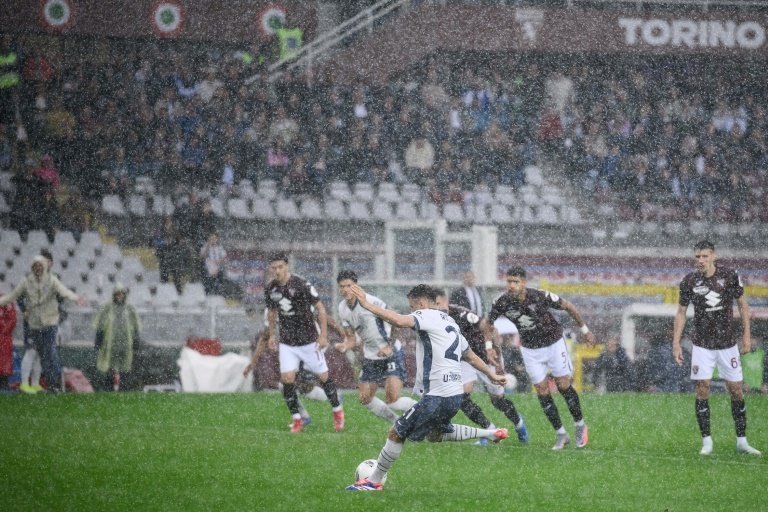 Inter Milan are still pushing to retain their Serie A title after claiming a dramatic 2-0 win at Torino in a match which was twice halted, for a powerful storm and a fan falling from a stand.