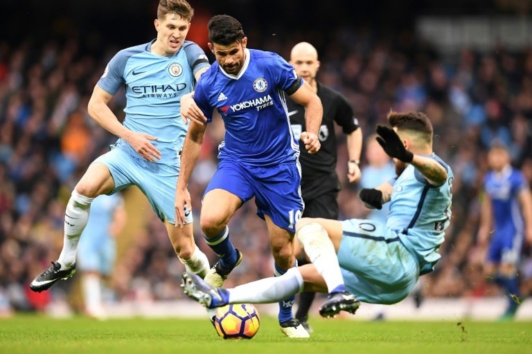 Chelseas striker Diego Costa (C) vies with Manchester Citys defender John Stones (L) and defender Nicolas Otamendi during the English Premier League football match December 3, 2016
