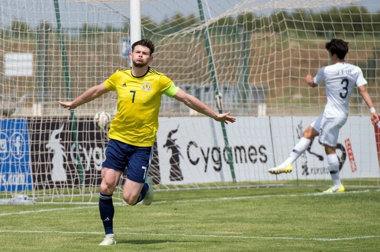 Oliver Burke tapped in to seal a victory that sees Scotland move up to third. AFP