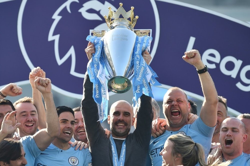 Manchester City manager Pep Guardiola holds up the Premier League trophy. AFP