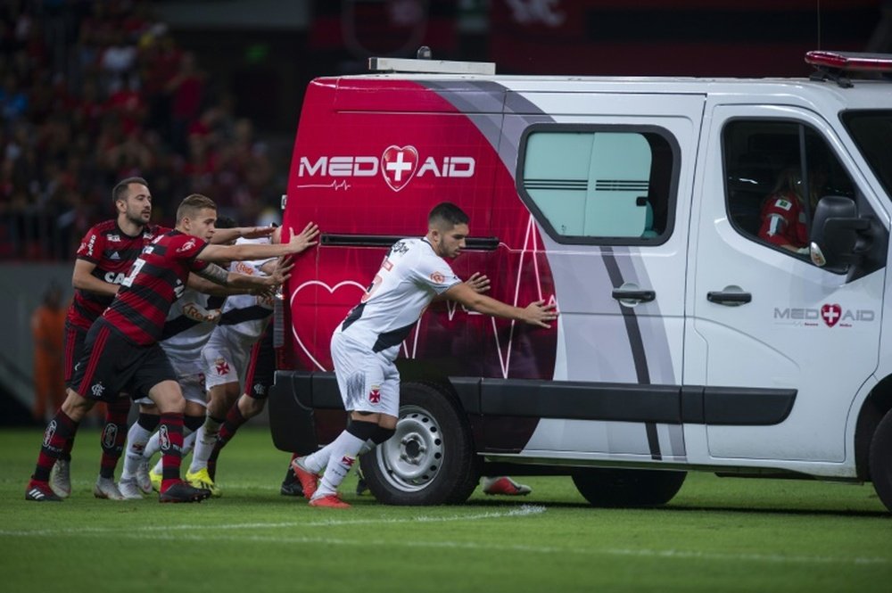 Players from both sides helped the vehicle off the pitch. AFP