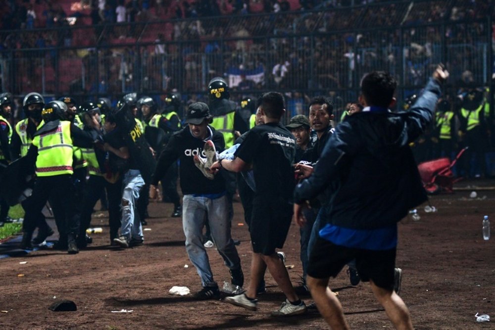 Fans died in players arms, says coach at Indonesia football tragedy. AFP