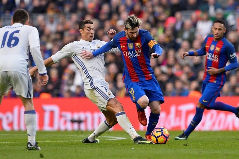Lionel Messi, à la lutte avec Cristiano Ronaldo. AFP