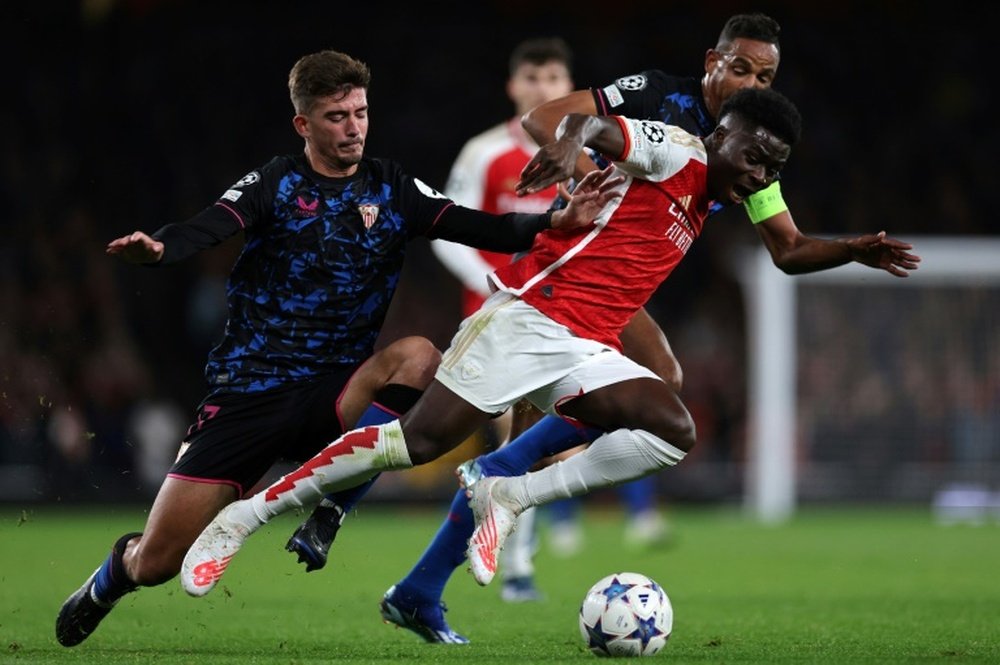 Bukayo Saka avec les Sévillans Fernando Reges (g) et Kike Salas. AFP