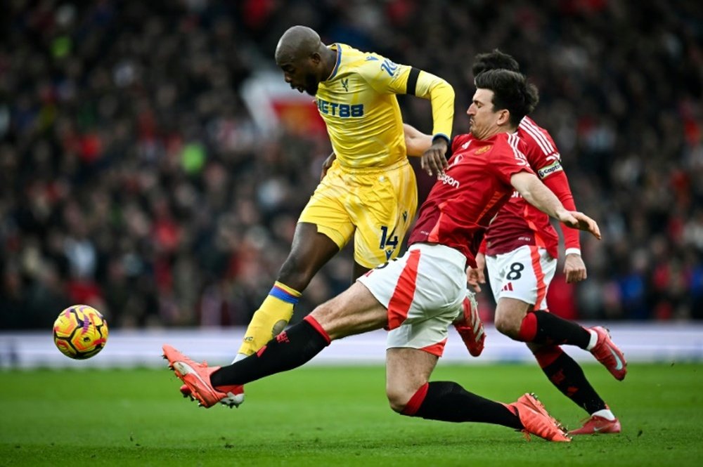 Maguire de Manchester United tacle Mateta de Crystal Palace. AFP