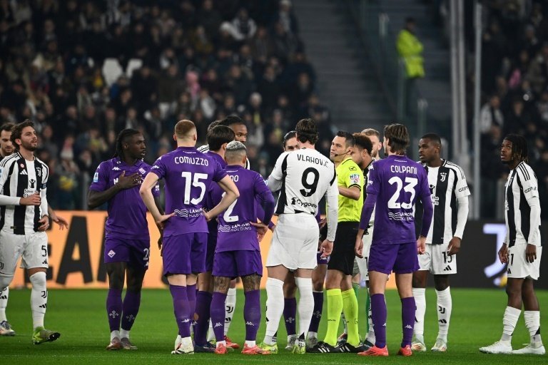 L'arbitre du match Juventus-Fiorentina M. Mariani explique aux joueurs quil interrompt le match. AFP