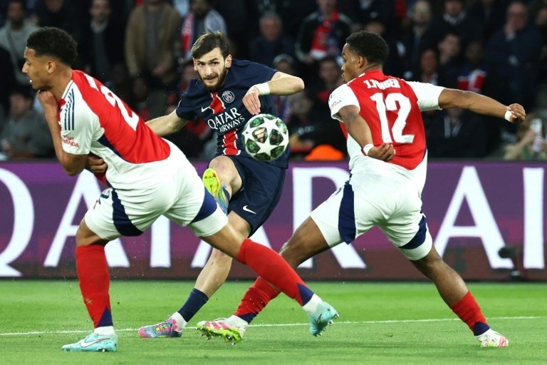 Le stratège géorgien du PSG Kvaratskhelia (C) frappe entre deux défenseurs d'Arsenal. AFP