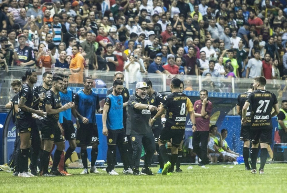 Diego Maradona, nouvel entraîneur du club mexicain des Dorados, exulte avec ses joueurs. AFP