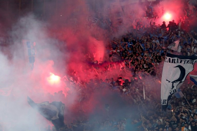 Des supporters de Naples craquent des fumigènes en tribune lors du match contre Cagliari. AFP