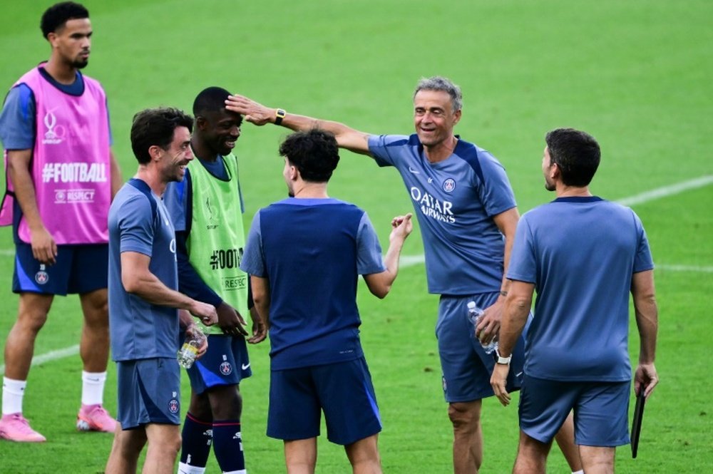 Lentraineur du PSG Luis Enrique et Dembele (au centre) plaisante lors dun entrainement. AFP