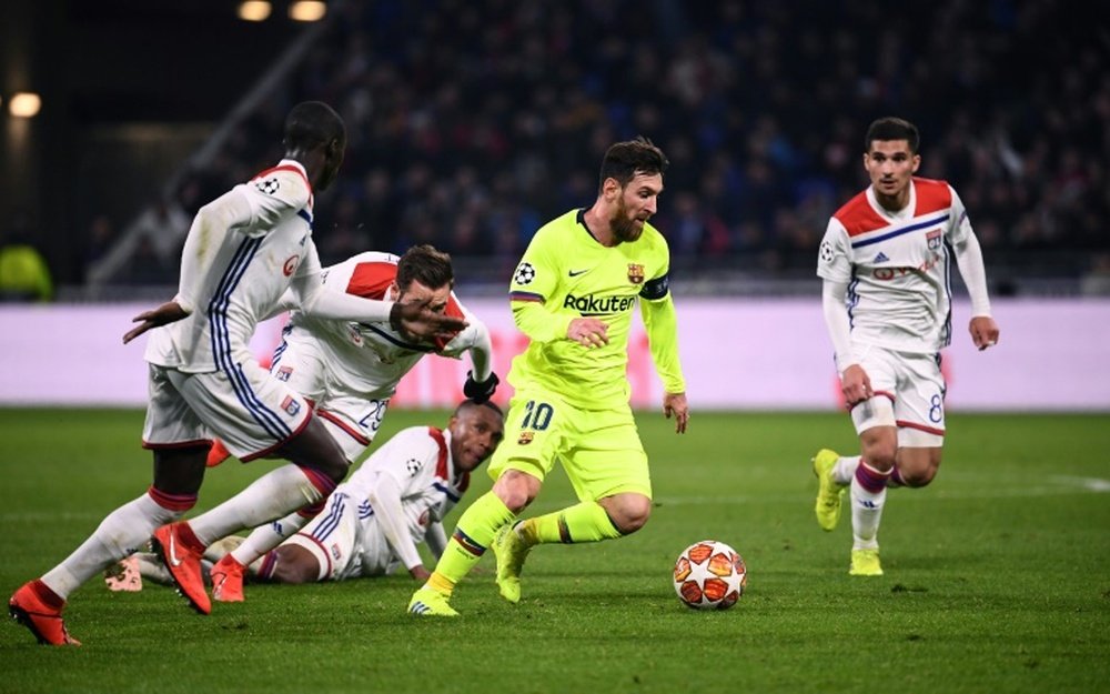 La star du FC Barcelone Lionel Messi cernée par la défense lyonnaise. AFP