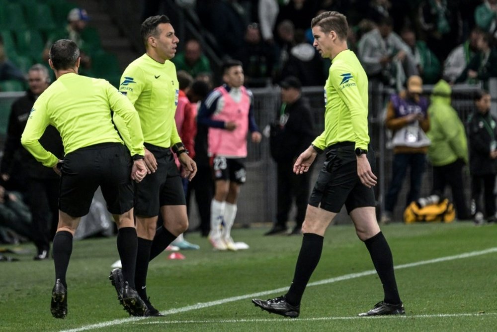 L'arbitre de touche Mehdi Rahmouni (centre), touché par un projectile durant le derby ASSE-OL. AFP