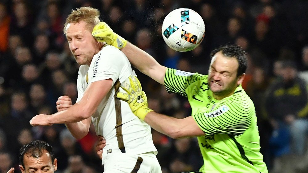 Kamil Glik heading the ball despite the goalkeeper's best efforts. Goal
