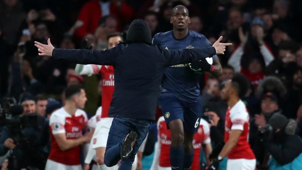 Paul Pogba was confronted by a pitch invader at the Emirates. GOAL