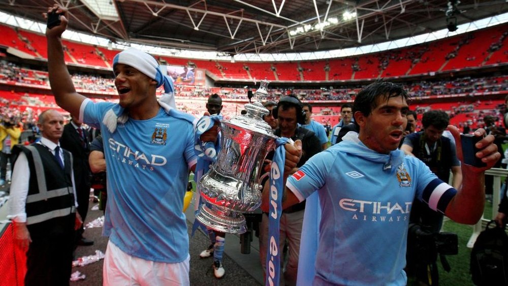 Vincent Kompany holds the FA Cup with Carlos Tevez. GOAL